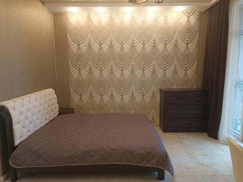 a bedroom with a bed and a wall at Сдам квартиру у моря Элегия парк Аркадия in Odesa