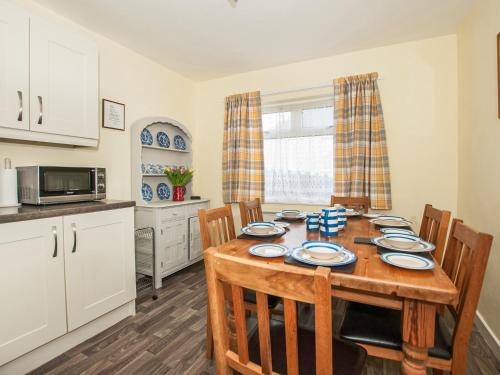 a kitchen and dining room with a table and chairs at Island View in Aberdaron