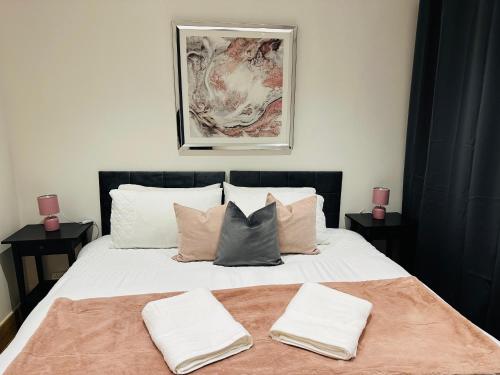 une chambre avec un lit avec deux serviettes dessus dans l'établissement Bright 2 Bedroom *2 Bathroom* 10 mins to East Croydon, à Croydon