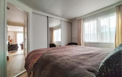 een slaapkamer met een groot bed en een groot raam bij Nice House In Putten in Putten