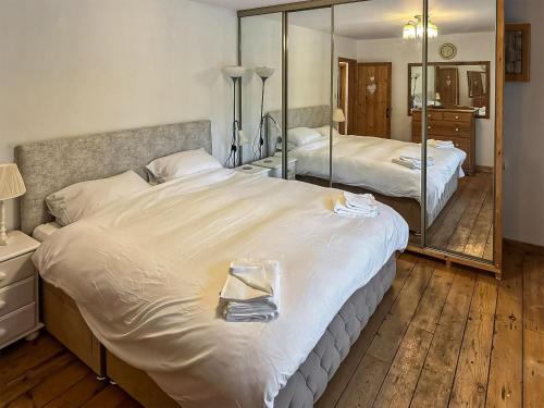 a bedroom with two beds and a large mirror at Marsh Cottage in Stockbridge