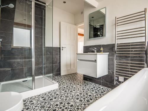 a bathroom with a shower and a sink and a tub at Sgwner View in Abererch