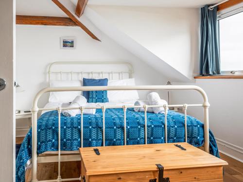 Schlafzimmer mit einem Bett mit blauer Decke in der Unterkunft Sgwner View in Abererch