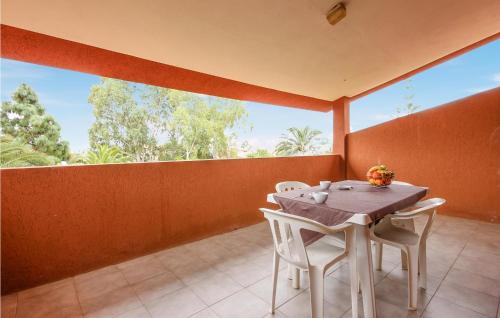 a dining room with a table and chairs on a balcony at 1 Bedroom Amazing Apartment In Costa Rei -Ca- in Costa Rei