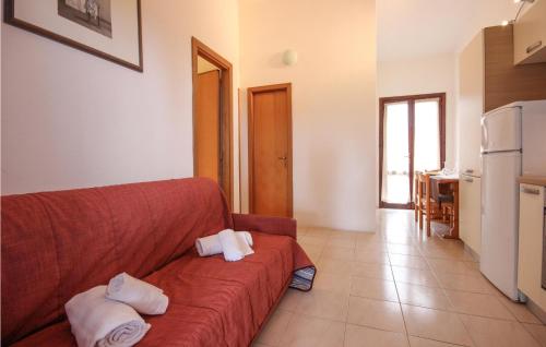a living room with a red couch with towels on it at 1 Bedroom Amazing Apartment In Costa Rei -Ca- in Costa Rei