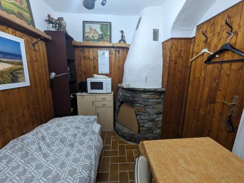 Kleines Zimmer mit einem Bett und einem Kamin in der Unterkunft Keltenpfad-Taunus Naturnah 