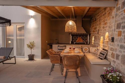 ein Wohnzimmer mit einem Sofa und einem Tisch mit Stühlen in der Unterkunft Pleiades Villas Naxos2 (Hottub) in Agkidia