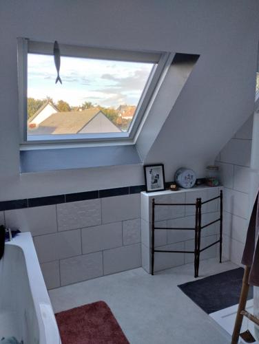 a bathroom with a window and a tub and a sink at chambres d'hôtes du clos du roi in Pontorson