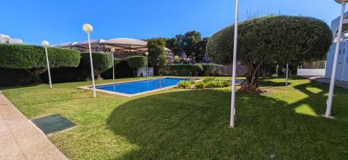 een tuin met een zwembad en een boom bij Residencial Aventino en pleno centro del L'Albir in Albir