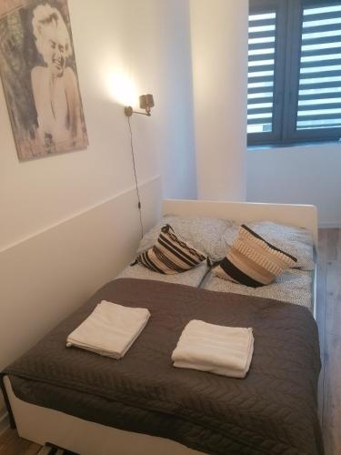 a bed with two towels on it in a room at Szczecin Hanza Tower APARTMENT-BASEN in Szczecin