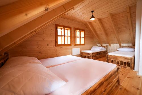 a bedroom with two beds in a wooden house at Chalupa Na Seníku - Beskydy, Valašsko - roubenka na samotě s výhledem in Vsetín