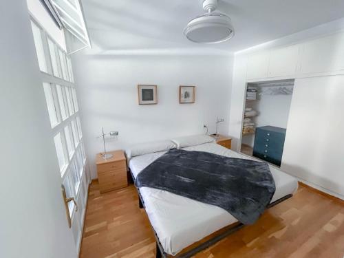 a bedroom with a bed with a black blanket on it at Martin´s Place in Alicante