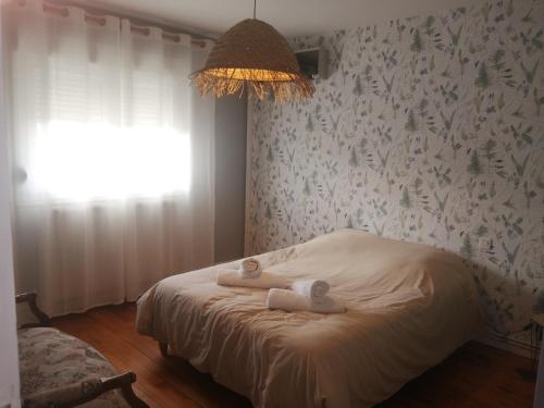 a bedroom with a bed with two towels on it at Les champs in Woimbey
