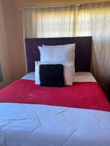 a black pillow sitting on top of a bed at Joyous Lodges in Cape Town