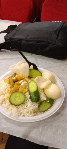 a plate of rice and vegetables on a table at Permata homestay in Karawang