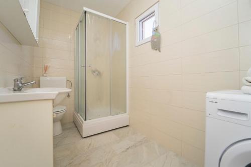 uma casa de banho com um chuveiro, um WC e um lavatório. em SVEMA APARTMAN em Vela Luka