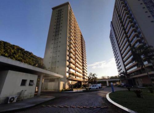 un edificio alto con un estacionamiento delante de él en Suíte Master - com vista panorâmica!!!, en Río de Janeiro