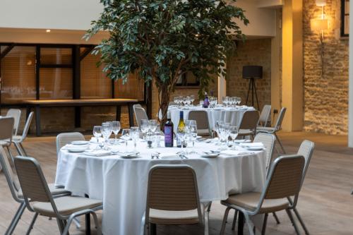 a group of tables with white table cloths and chairs at voco Oxford Thames by IHG in Oxford