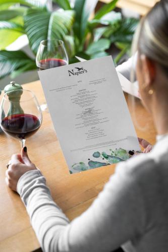 a woman sitting at a table with a glass of wine at voco Oxford Thames by IHG in Oxford