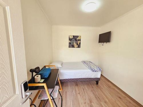 een kleine kamer met een bed, een bureau en een televisie bij Alojamiento Privado 502 en Antofa in Antofagasta