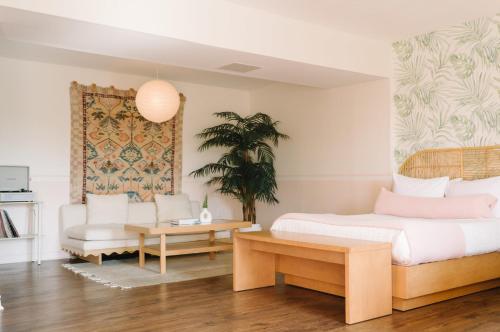 ein Schlafzimmer mit einem Bett, einem Sofa und einem Tisch in der Unterkunft The June Motel in Picton