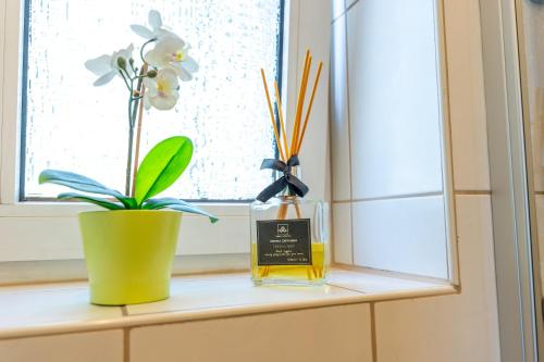 a window sill with a bottle of perfume and a plant at Ferienvilla Koblenz in Koblenz