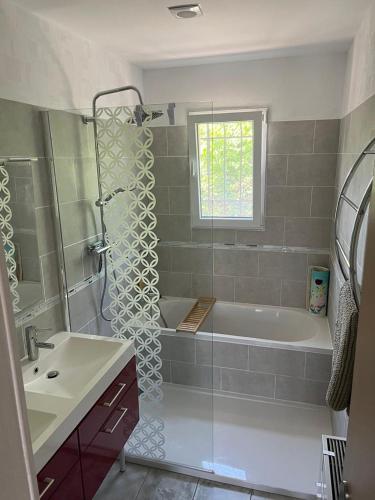 La salle de bains est pourvue d'une douche, d'une baignoire et d'un lavabo. dans l'établissement La maison POP, à Saint-Gaudens