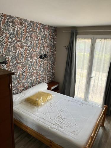 - une chambre avec un lit et un mur à publicité dans l'établissement La maison POP, à Saint-Gaudens