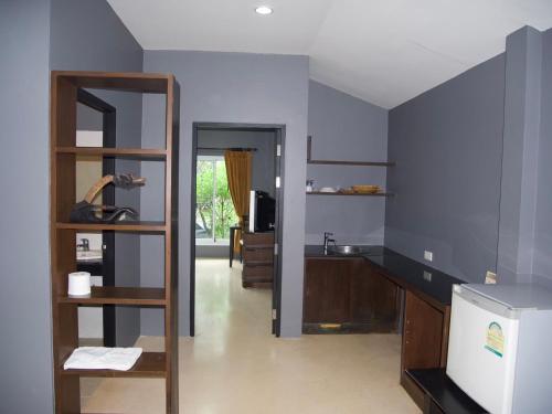 una cocina con paredes azules y una estantería de madera. en Mindful Kinesics Wellness Living, en Nathon Bay