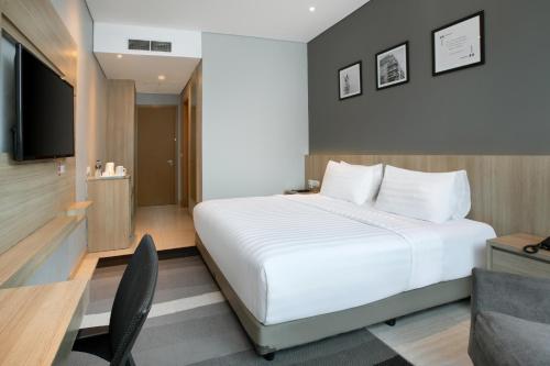 a hotel room with a bed and a television at Grand Tjokro Premiere Bandung in Bandung