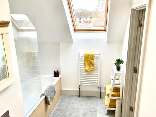 a bathroom with white walls and a skylight at Westbury Cross House Bed & Breakfast in Westbury-sub-Mendip