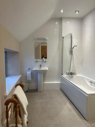 a bathroom with a tub and a sink and a bath tub at Horse and Groom Inn in Banbury