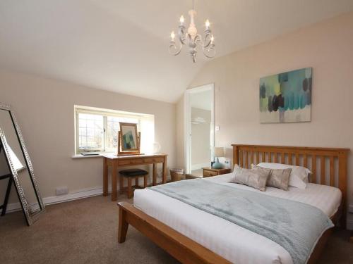 a bedroom with a bed and a desk and a chandelier at Horse and Groom Inn in Banbury