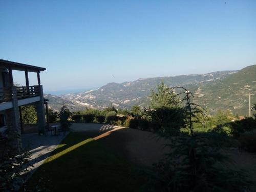 a road leading to a house with mountains in the background at Guesthouse Diochri in Kato Trikala Korinthias