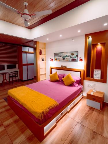 NedukandamにあるHomestay Podiyansのベッドルーム1室(ピンクと黄色のシーツが入った大型ベッド1台付)