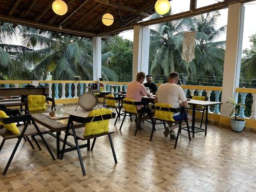 un grupo de personas sentadas en mesas en un restaurante en Iksa en Mandrem