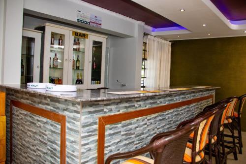 eine Bar in einem Restaurant mit Stühlen drum herum in der Unterkunft Mojoh Inn Hotel in Ambira