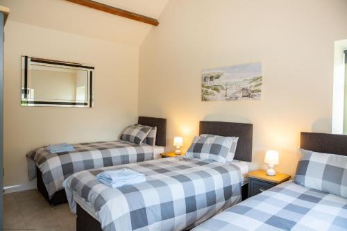 two twin beds in a room with two lamps at Stables Cottage in Selby
