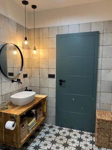 La salle de bains est pourvue d'un lavabo et d'une porte bleue. dans l'établissement Design apartmán v zahradě, à Hlinsko