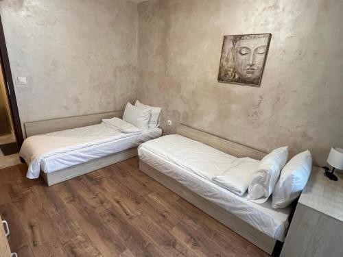 zwei Betten in einem Zimmer mit einem Bild an der Wand in der Unterkunft Апартамент Комфорт 2 Близо до Летището in Sofia