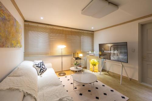 a living room with a couch and a tv at Free pick-up, 4 Beds, near Gangnam, Hongdae, Subway 8 mins, Spacious in Seoul