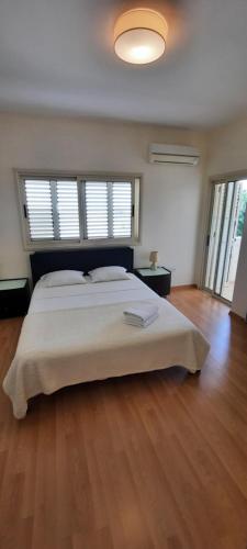 ein Schlafzimmer mit einem großen Bett und Holzböden in der Unterkunft Villa Larnaca Bay Resort in Oroklini
