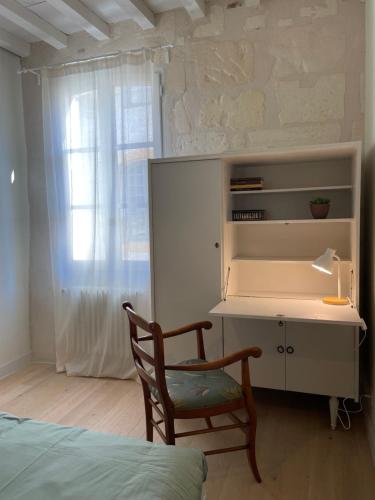 Résidence Léonard - Centre historique Arles في آرل: غرفة نوم بها مكتب وكرسي ونافذة