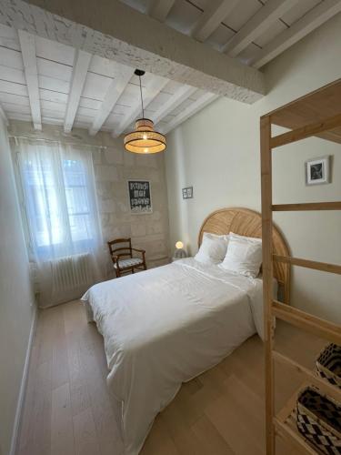 a bedroom with a large white bed and a window at Résidence Léonard - Centre historique Arles in Arles