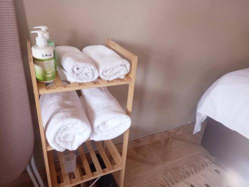 a towel rack with towels and a pile of towels at Sally's Tranquil Airbnb in Centurion