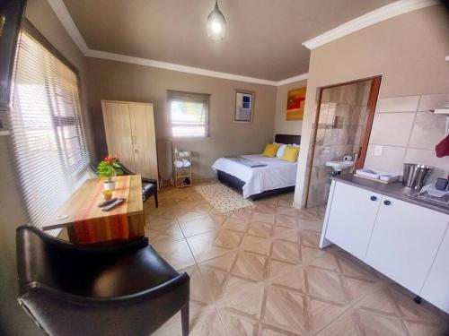 a bedroom with a bed and a desk in a room at Sally's Tranquil Airbnb in Centurion