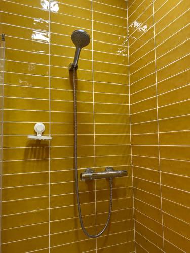 a shower with a shower head on a yellow wall at Casa Triana in Soure