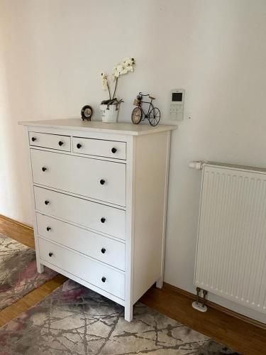 a white dresser with flowers on top of it at Mobilierte 5 Zimmer Wohnung zur vermieten in Frankfurt