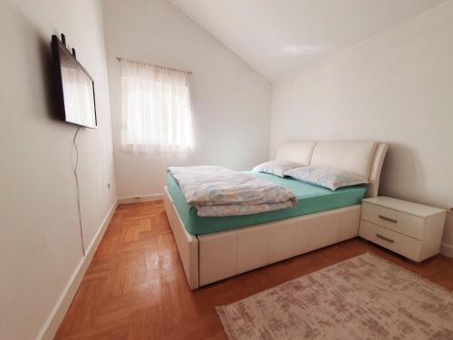 a small bedroom with a bed and a window at Luxury Penthouse in Široki Brijeg