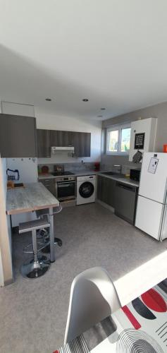 Il comprend une cuisine équipée d'un réfrigérateur et d'une table avec une chaise. dans l'établissement La pause, à Creuzier-le-Vieux